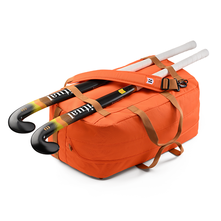 Ritual Calibre hockey duffle bag orange with two hockey sticks 