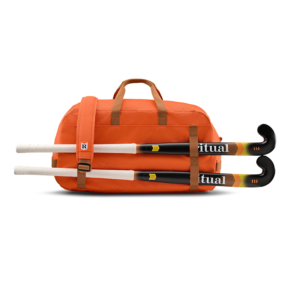 Orange Ritual Hockey bag with two hockey sticks on a white background